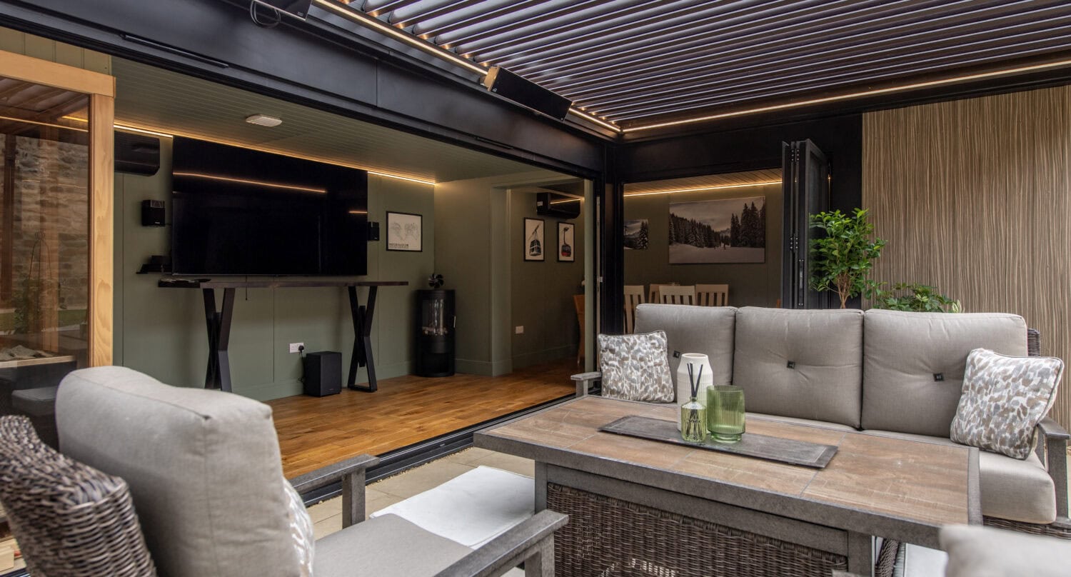 Contemporary indoor lounge featuring large bi-fold doors opening to an outdoor space, with comfortable seating and modern decor.